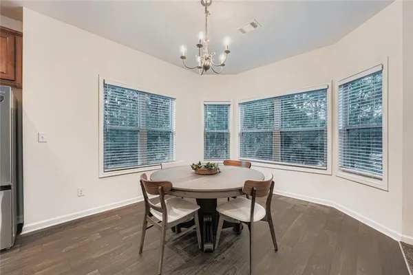 a dining room with furniture large windows and a chandelier