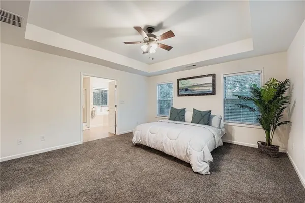 a spacious bedroom with a bed and a chandelier