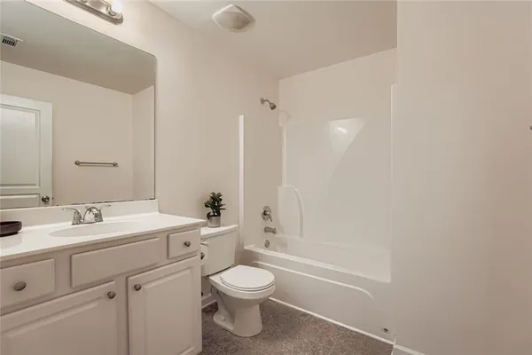 a bathroom with a toilet a sink a tub and mirror