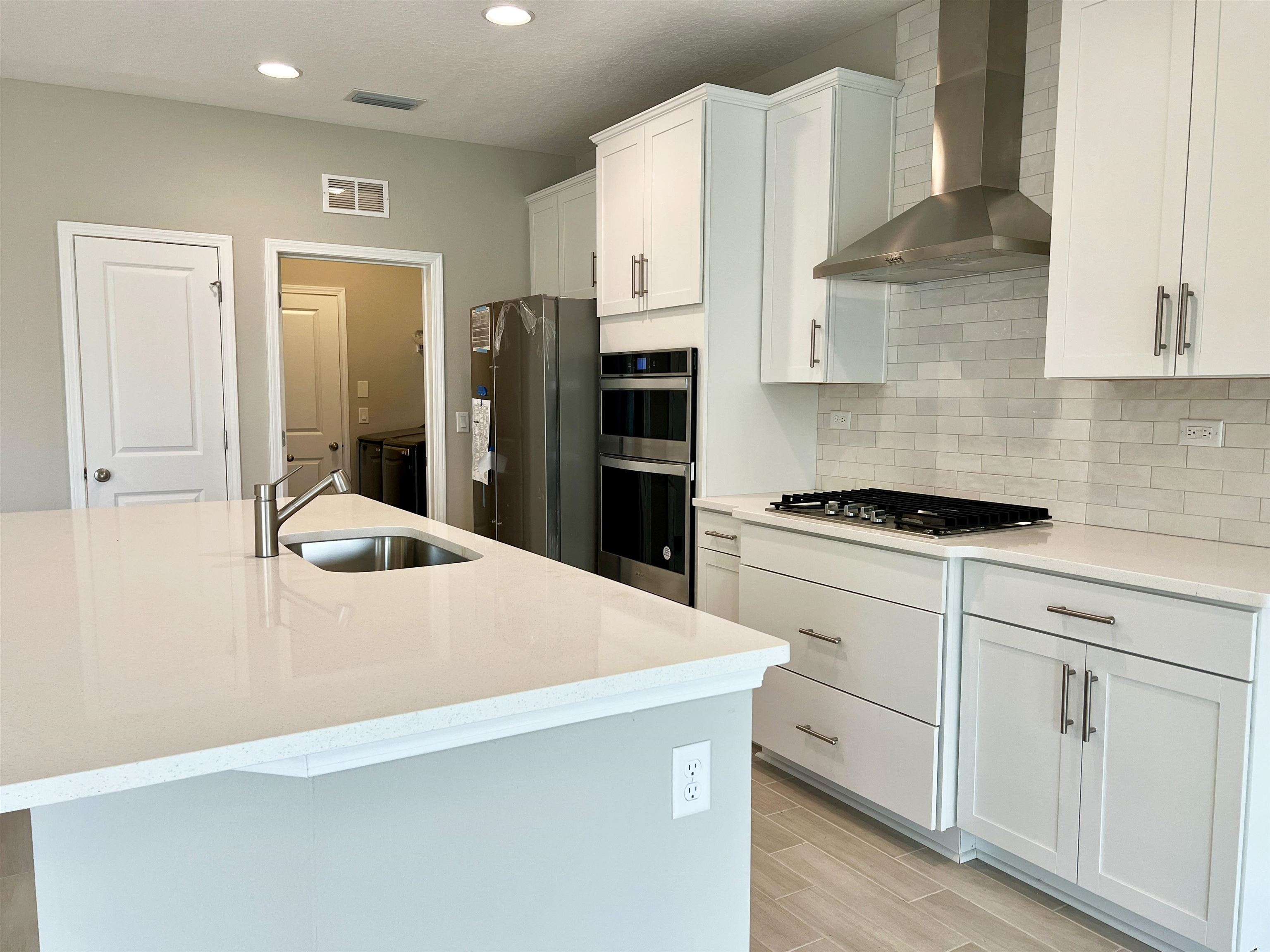 385 Brookgreen Way St. Augustine, FL 32092 - Photo 10 of 31 a kitchen with white cabinets and stainless steel appliances