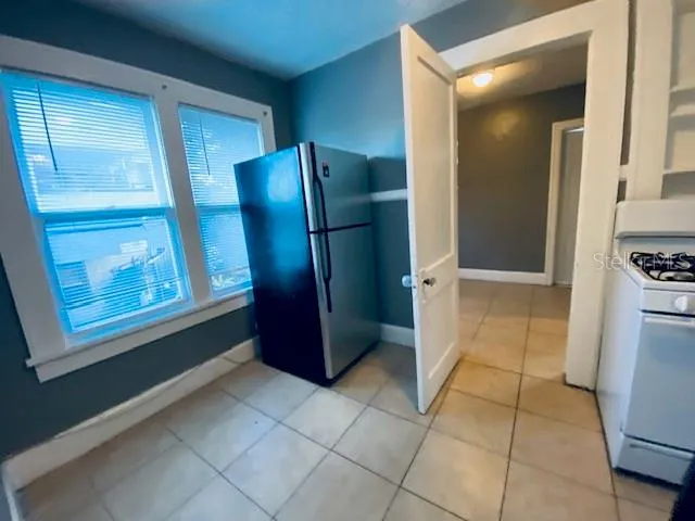 a view of kitchen with windows and refrigerator