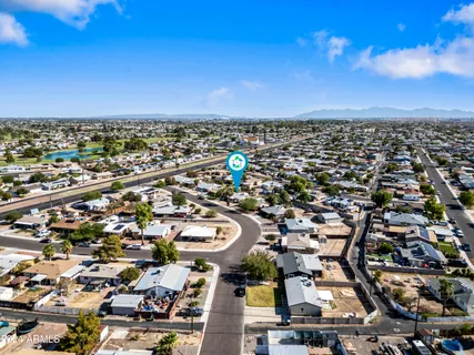 an aerial view of a city with lots of residential buildings and ocean view in back