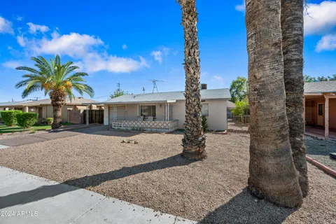 a front view of a house with a yard and potted plants