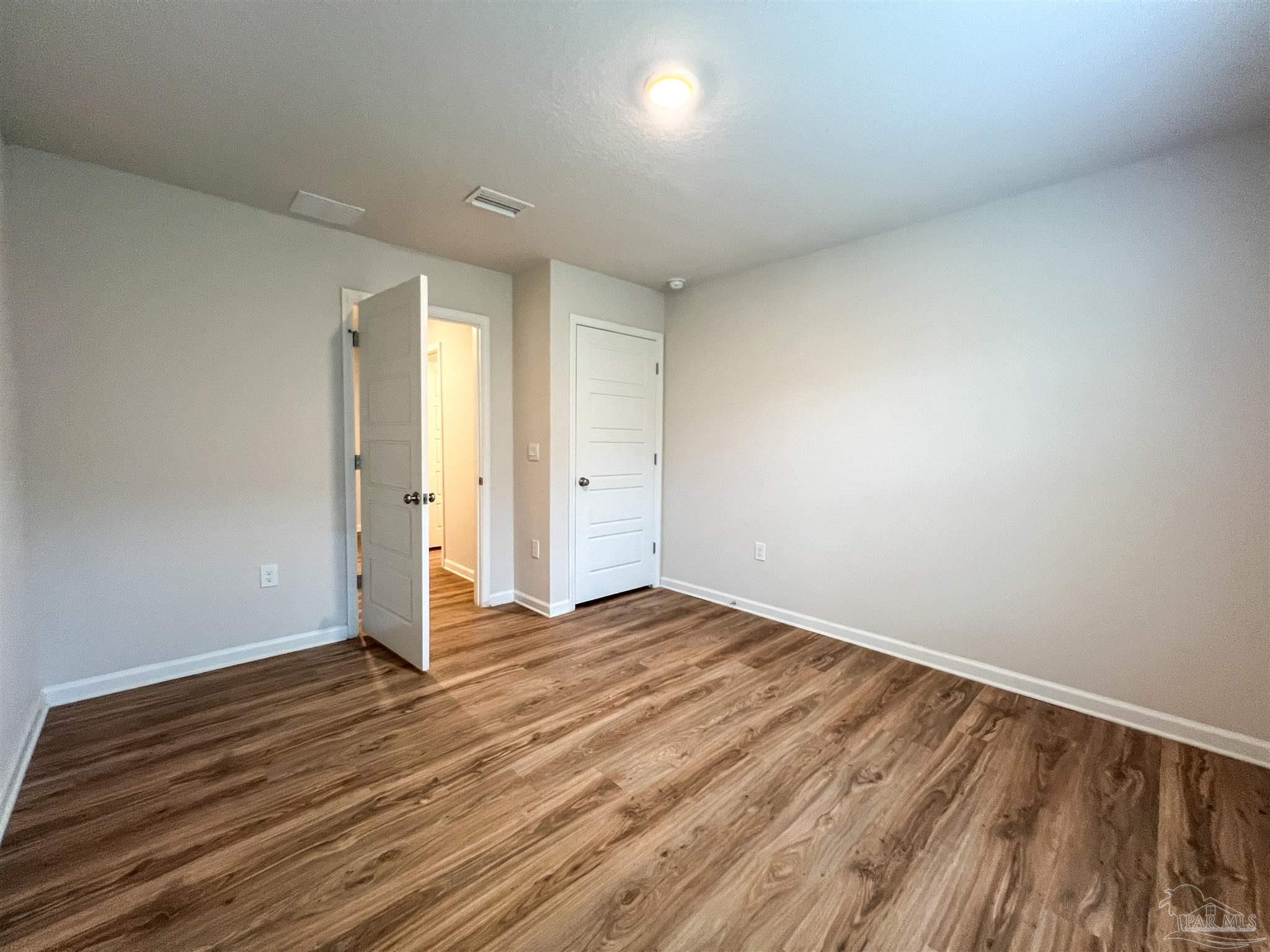 6351 Burrow Lane Pensacola, FL 32526 - Photo 17 of 25 a view of an empty room and wooden floor