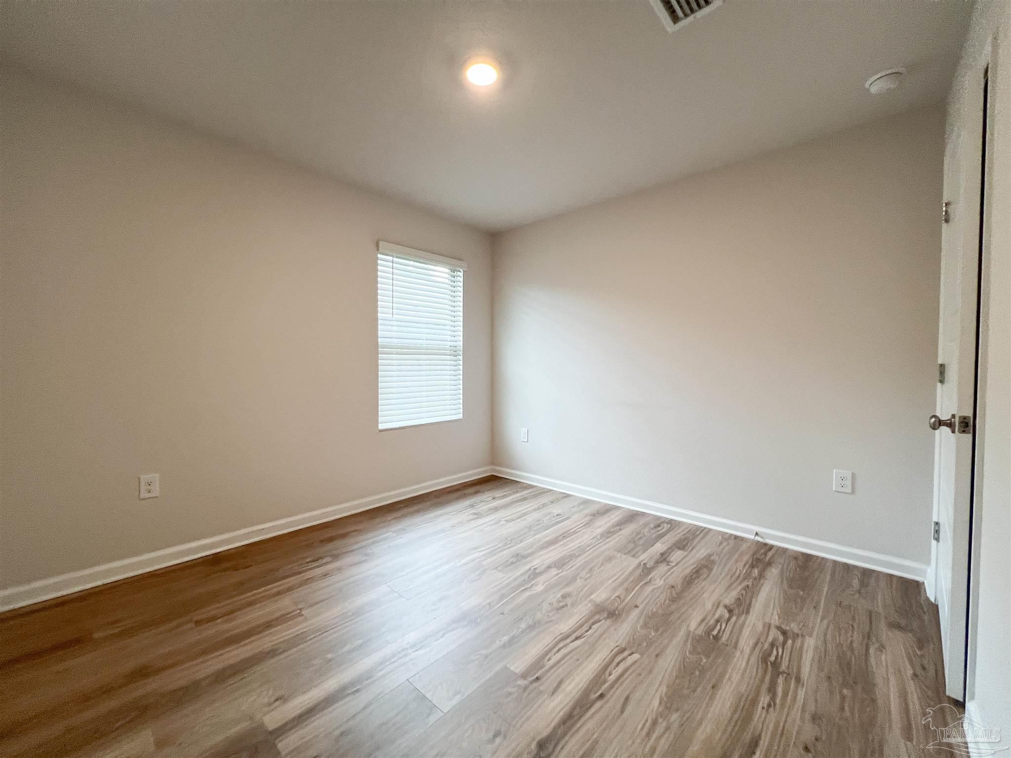 6351 Burrow Lane Pensacola, FL 32526 - Photo 24 of 25 a view of an empty room with wooden floor and a window