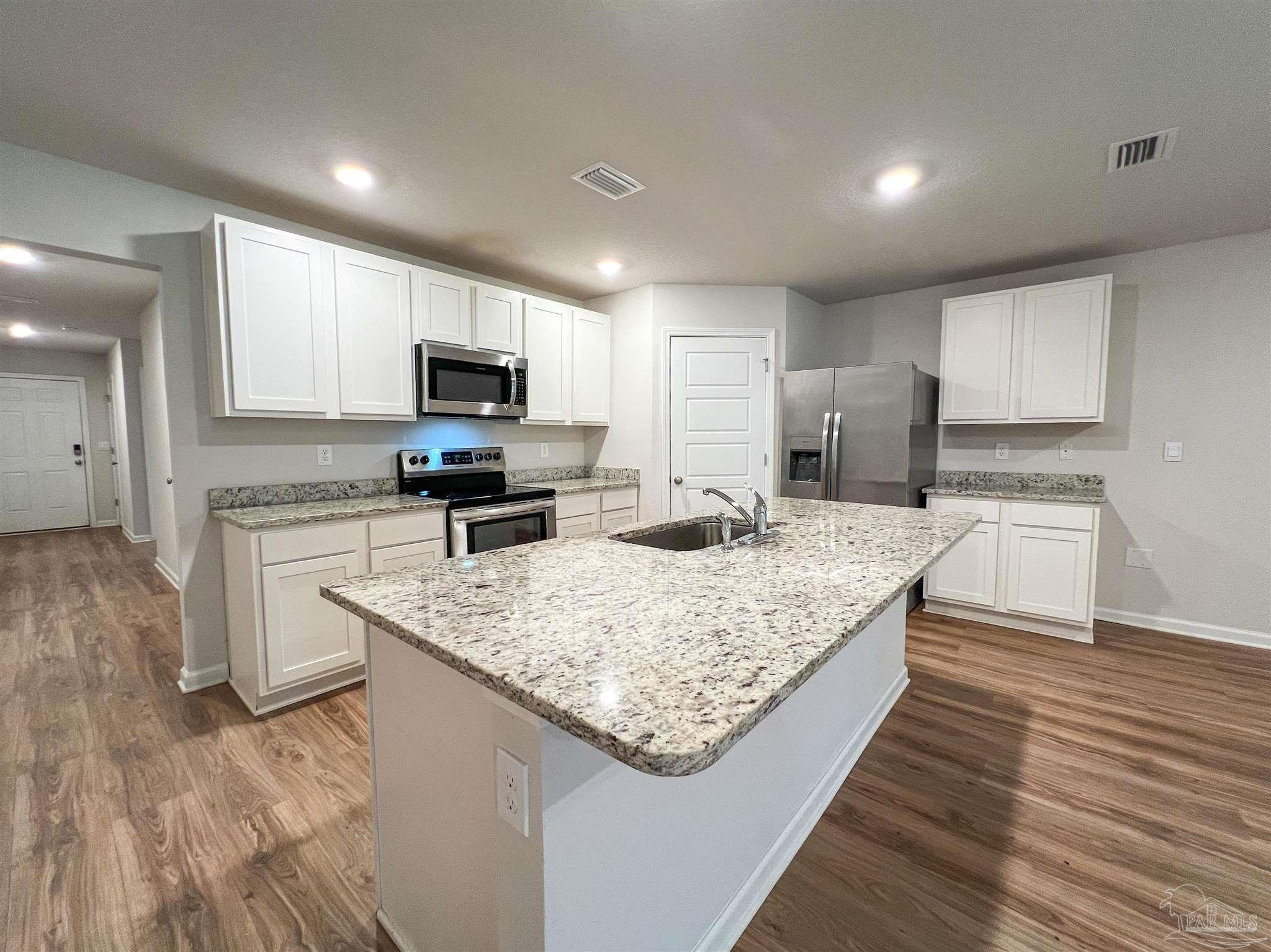 6351 Burrow Lane Pensacola, FL 32526 - Photo 5 of 25 a kitchen with granite countertop a stove top oven a sink dishwasher and a refrigerator with wooden floor