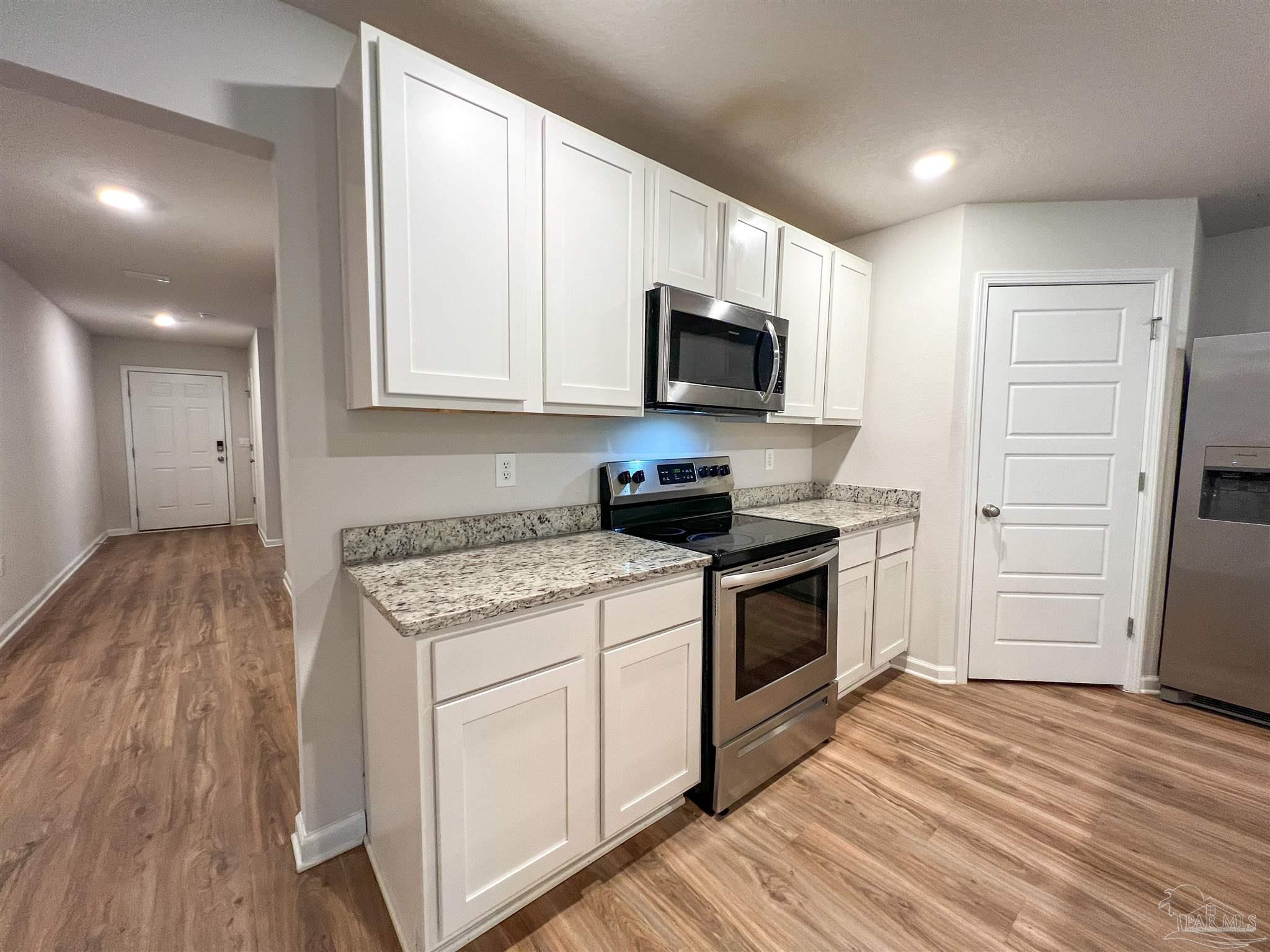 6351 Burrow Lane Pensacola, FL 32526 - Photo 6 of 25 a kitchen with a stove a sink and a microwave