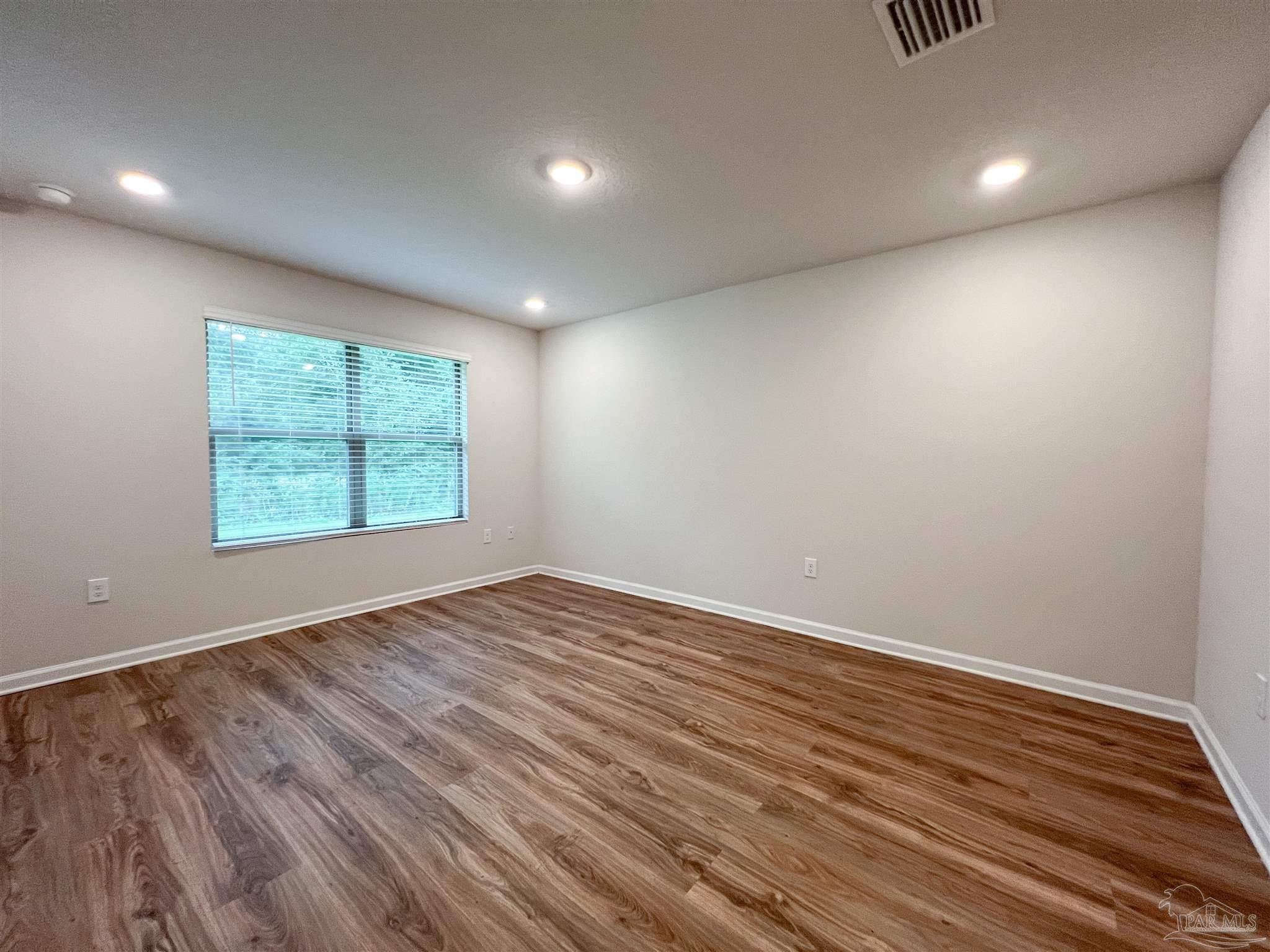 6351 Burrow Lane Pensacola, FL 32526 - Photo 9 of 25 an empty room with wooden floor and windows