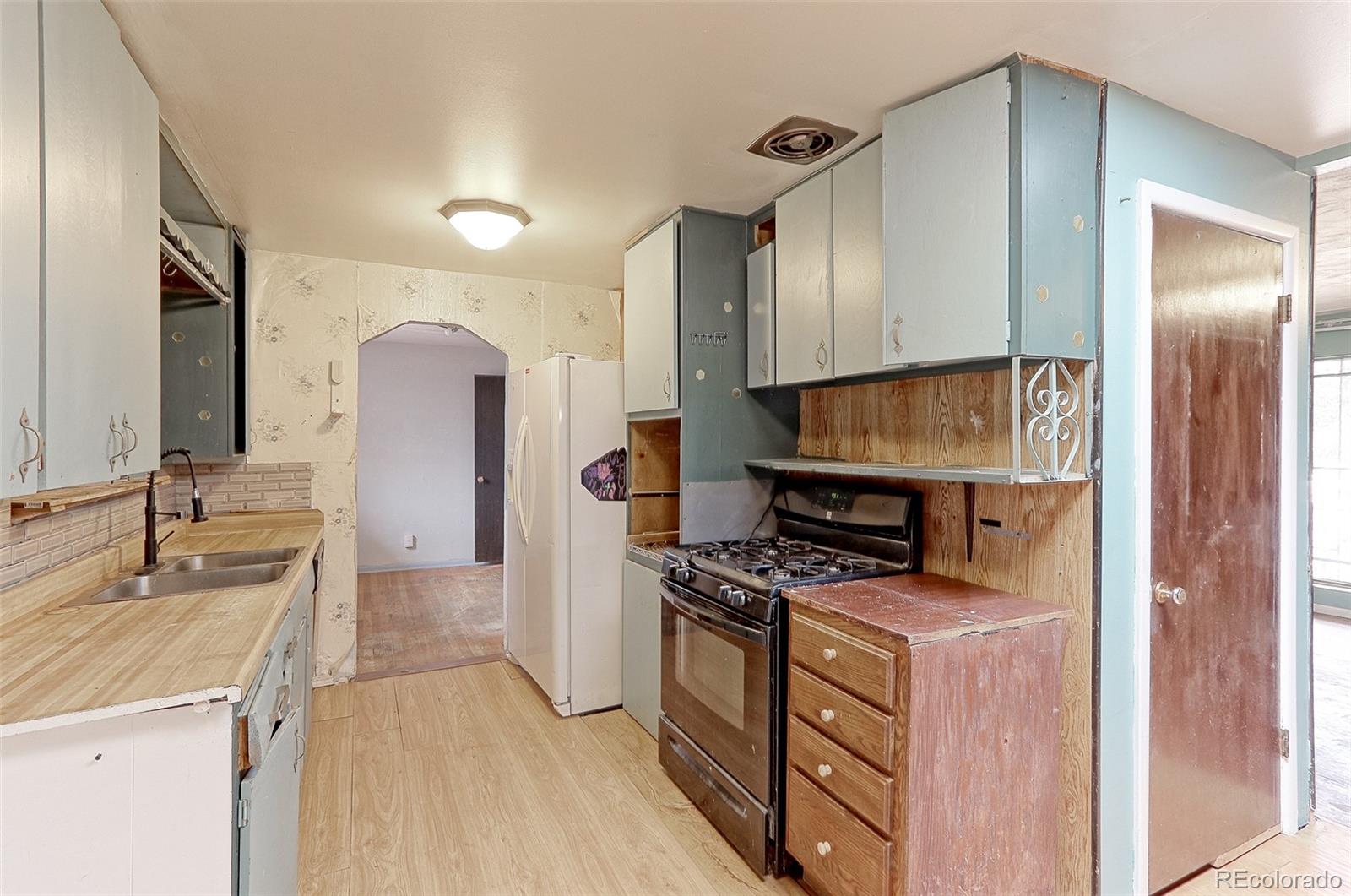 7190 Beach Street Westminster, CO 80030 - Photo 5 of 19 a kitchen with stainless steel appliances a stove a sink a refrigerator and a oven