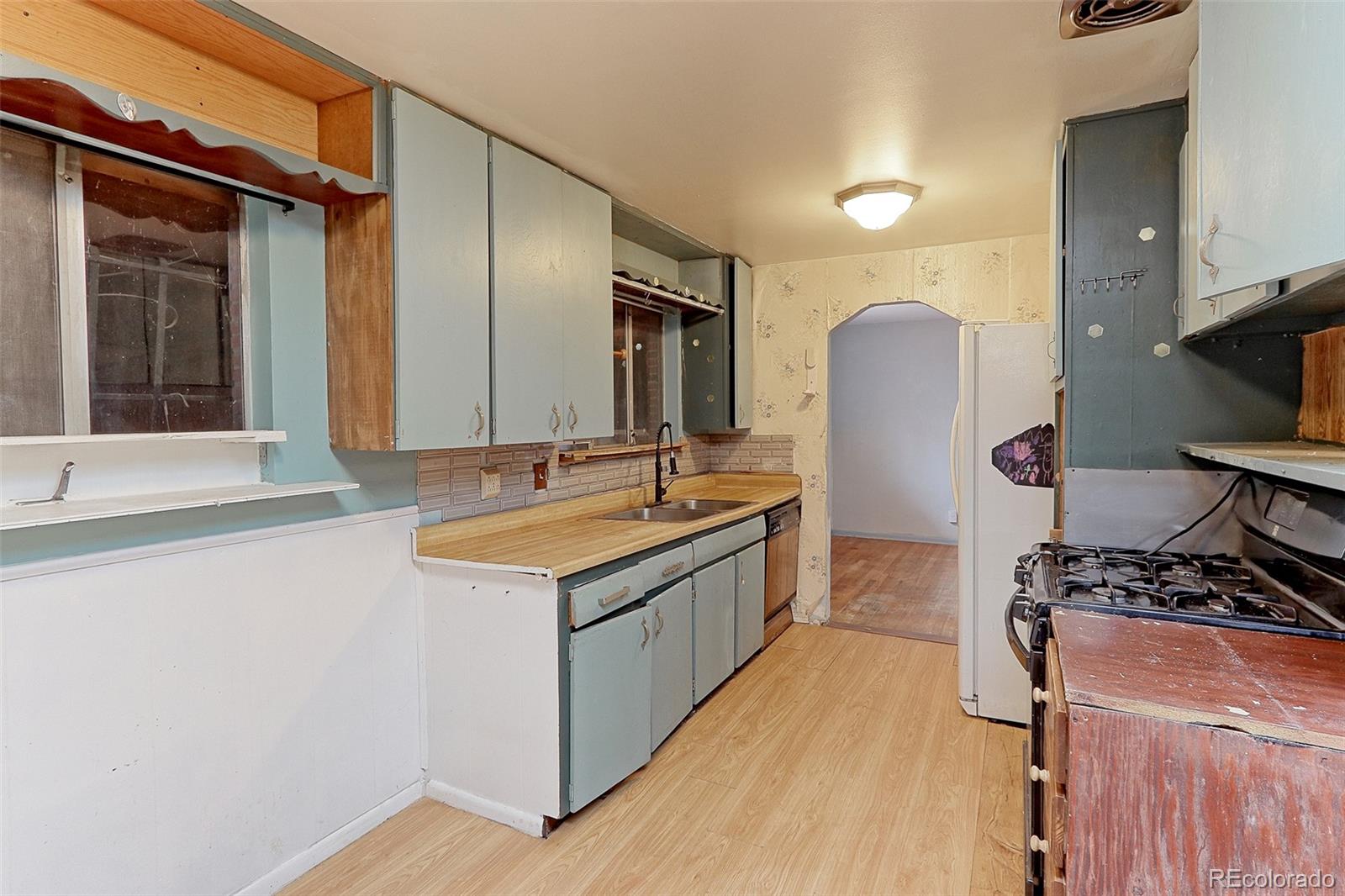 7190 Beach Street Westminster, CO 80030 - Photo 6 of 19 a kitchen with stainless steel appliances granite countertop a sink stove and refrigerator