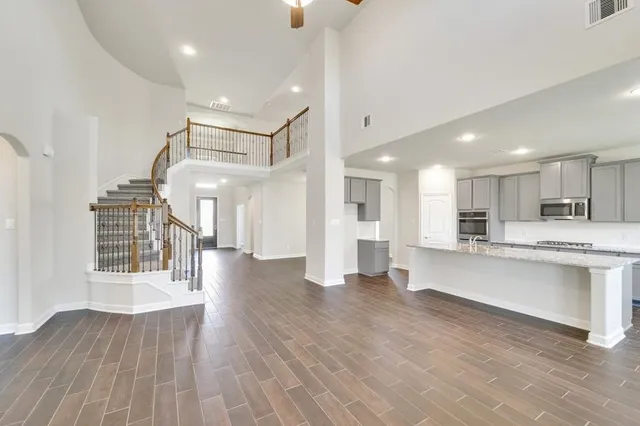 a large kitchen with a fireplace and wooden floor