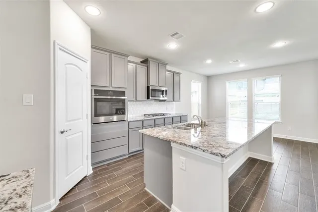 a kitchen with granite countertop a sink and cabinets