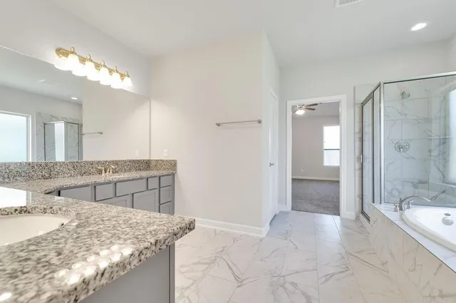 a bathroom with a granite countertop double vanity and a sink