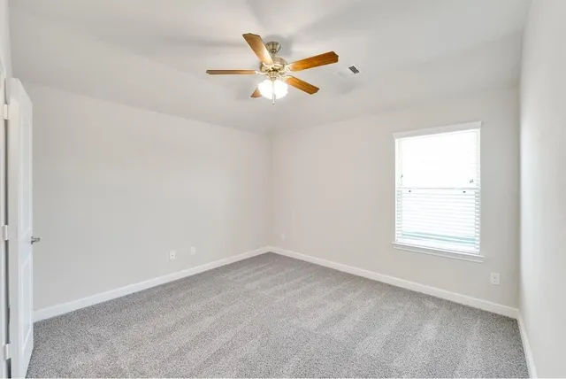 an empty room with closet and windows