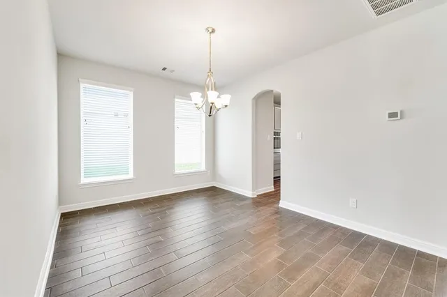 a view of a room with wooden floor chandelier and window