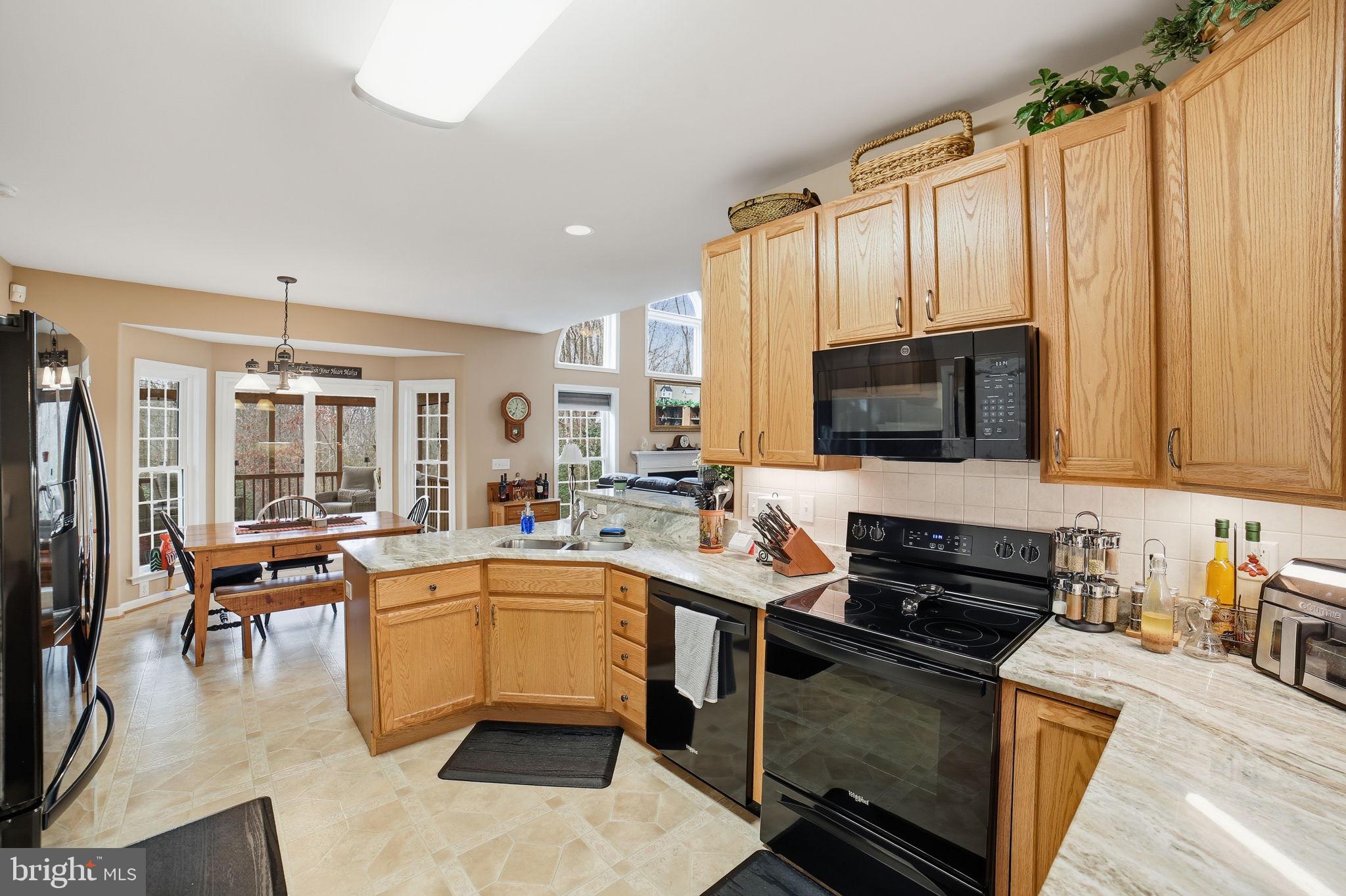 7730 Riparian Court Fredericksburg, VA 22408 - Photo 7 of 24 a kitchen with stainless steel appliances a stove sink microwave and cabinets