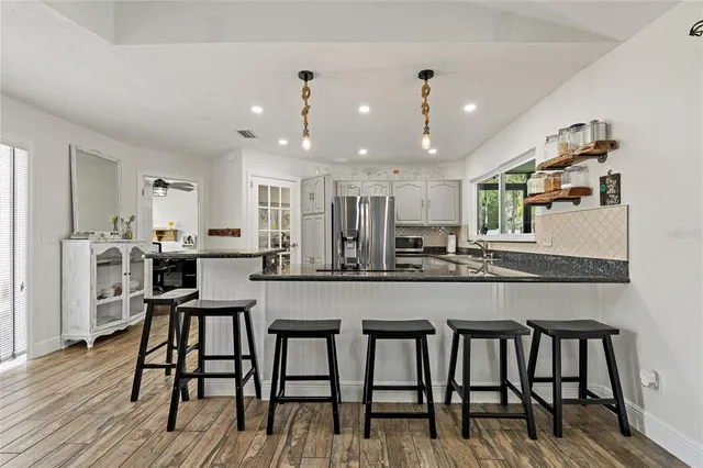 a living room with furniture and a view of kitchen
