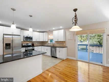 a kitchen with stainless steel appliances granite countertop a sink a stove and refrigerator