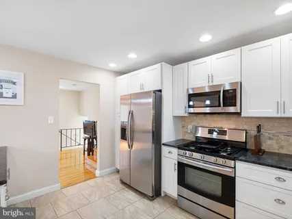 a kitchen with stainless steel appliances granite countertop a refrigerator stove and microwave
