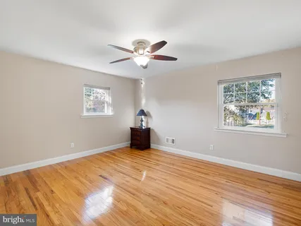a view of an empty room with window and wooden floor