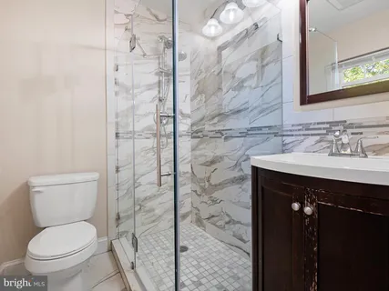 a bathroom with a sink a toilet and shower