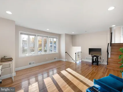 a spacious bedroom with a large bed a chandelier and windows