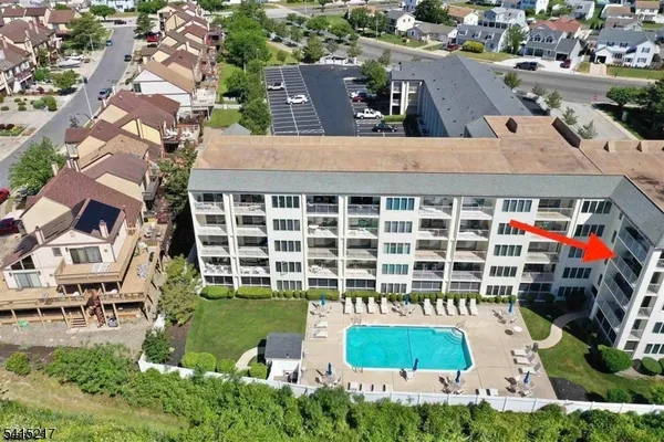 an aerial view of residential houses with outdoor space and parking