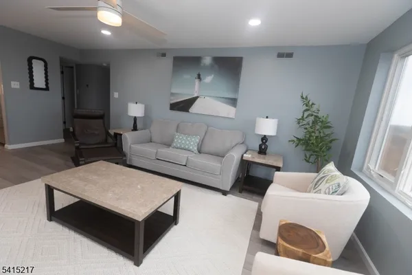 a living room with furniture and a wooden floor