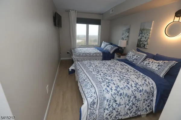a bedroom with a bed and a lamp with wooden floor