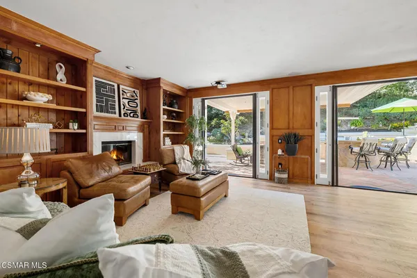 a living room with furniture large window and a fireplace