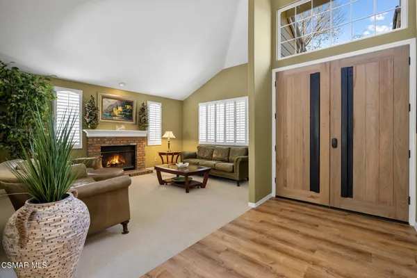 a living room with furniture large window and a fireplace