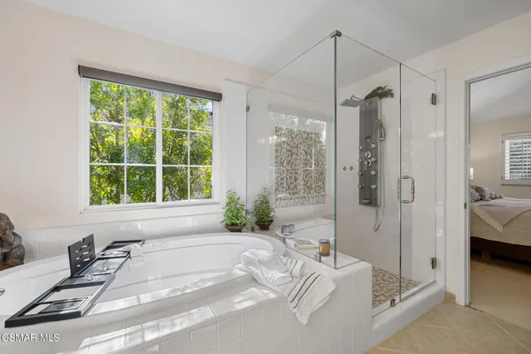 a spacious bathroom with a tub and a large window
