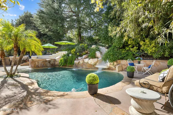 a view of a patio with couches table and chairs potted plants and palm trees
