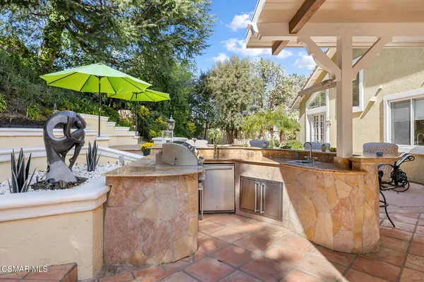 a view of a patio with a table and chairs under an umbrella