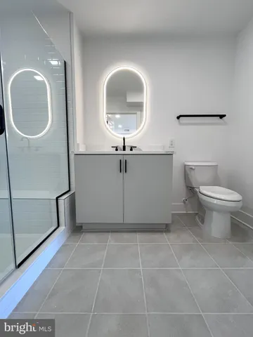 a bathroom with a toilet a sink and mirror