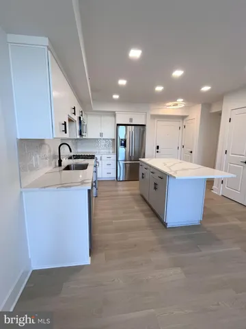 a large kitchen with kitchen island a sink stainless steel appliances and cabinets