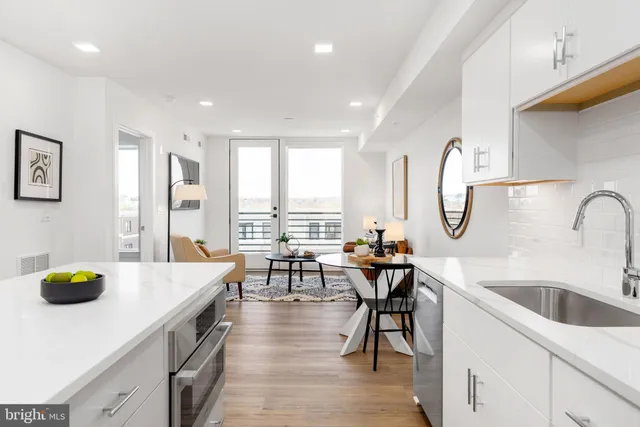 a kitchen with a table chairs sink and wooden floor