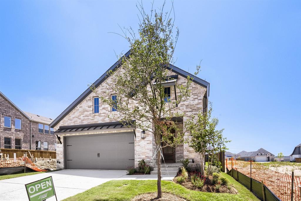 828 Stone Grv Road Lavon, TX 75166 - Photo 27 of 27 Contemporary brick facade with dark trim, featuring a prominent gable roofline and a two-car garage