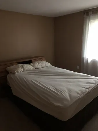 a bed sitting in a bedroom next to a window