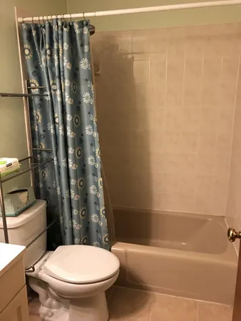 a white toilet sitting next to a bath tub and shower