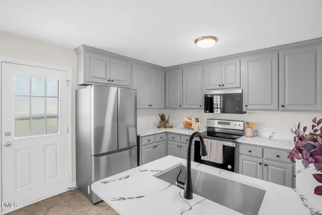 a kitchen with stainless steel appliances a refrigerator stove microwave and sink