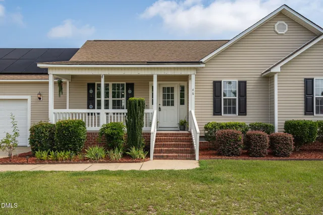 a front view of a house with a garden