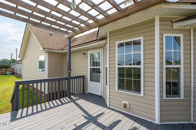 a view of a deck that has wooden floor and a window