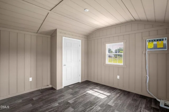 a view of an empty room with closet and a window