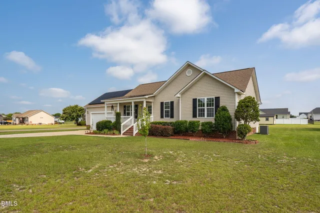 a view of a house with a big yard and potted plants