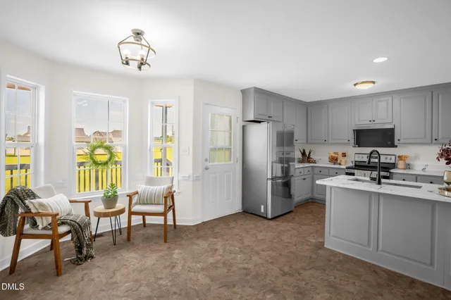 a kitchen with refrigerator a sink and chairs