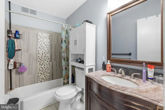 a bathroom with a granite countertop sink toilet and shower