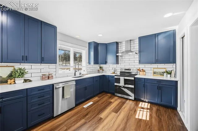 a kitchen with wooden floors wooden cabinets a sink and appliances