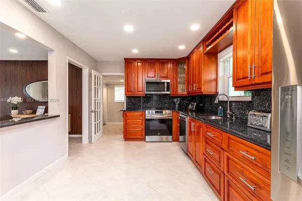 a kitchen with stainless steel appliances granite countertop wooden cabinets a sink and a stove