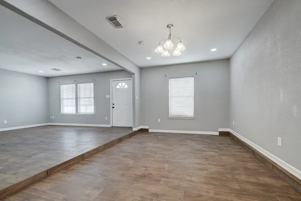 a view of empty room with wooden floor